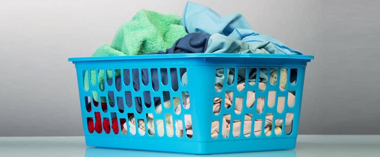 blue laundry basket filled with dirty laundry
