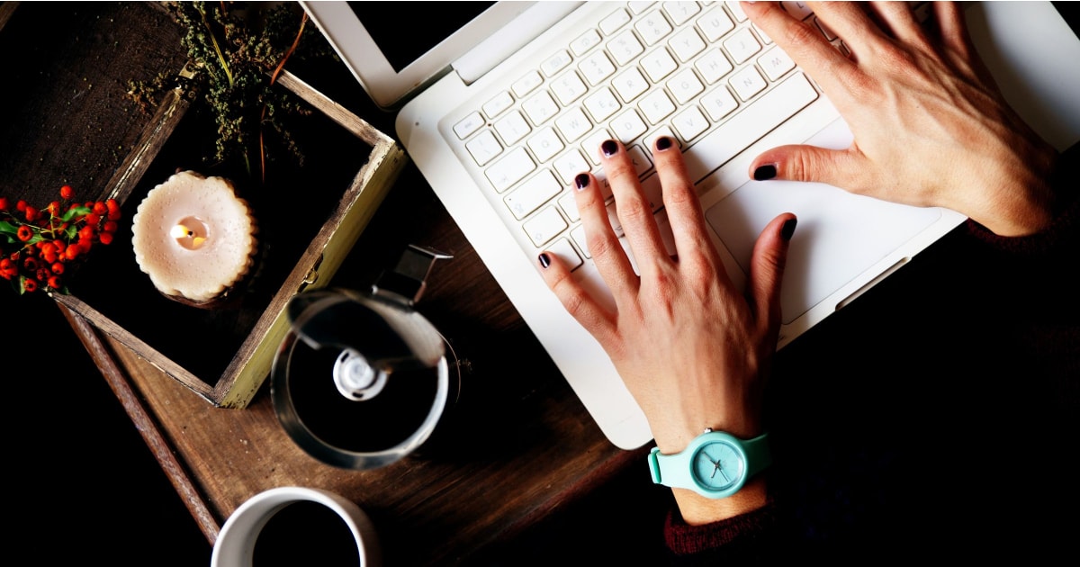 stylish working mom's hands typing on macbook