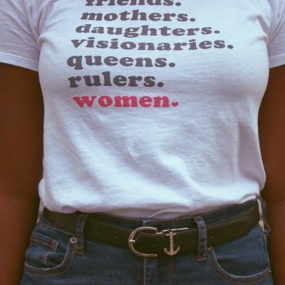 graphic t-shirt reads "friends. mothers. daughters. visionaries. queens. rulers. women."