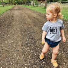 A little girl walking on a gravel path