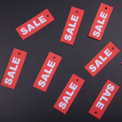 a number of red tags that say "SALE," laid on a table