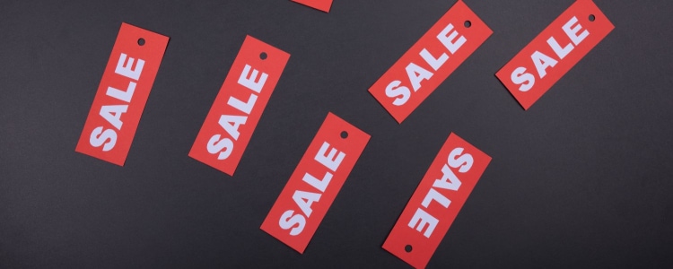 a number of red tags that say "SALE," laid on a table