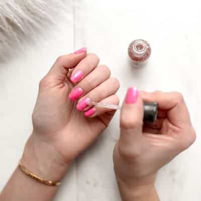 A woman applying cuticle oils to her nails