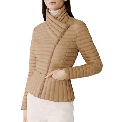 A woman wearing an asymmetrical-neck tan winter coat and white pants