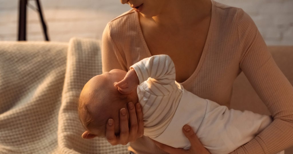 A mother holding an infant child