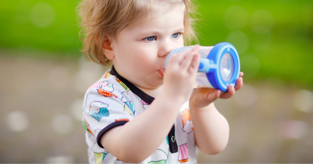 A child drinking from a blue Sippy Cup