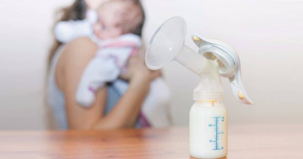 A bottle of breast milk with a pump.