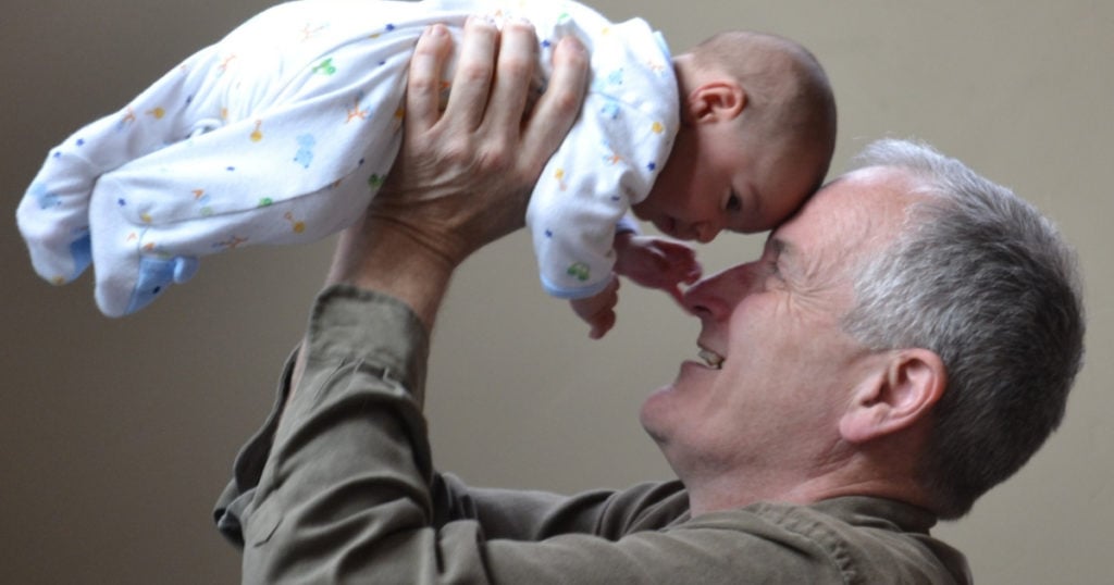 A man holding up a baby