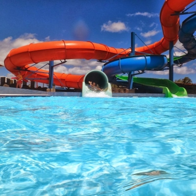 A waterpark with two people coming out of a slide