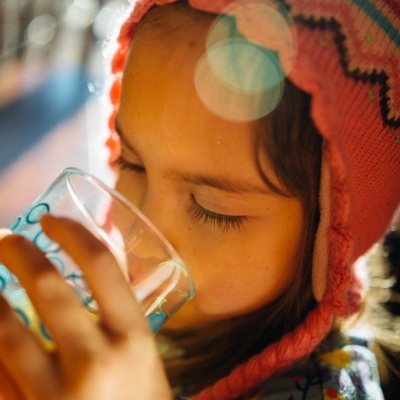 A little girl drinking water from a glass