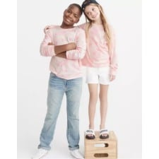 Two girls wearing pink sweaters 