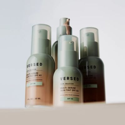 three frosted pump bottles of tinted facial serum with SPF 40 in varying shades, displayed against a neutral background