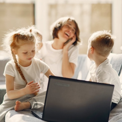 A mother and her children infront of a laptop
