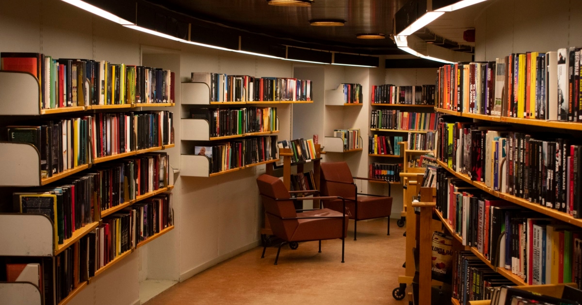 A room with a book shelf filled with books