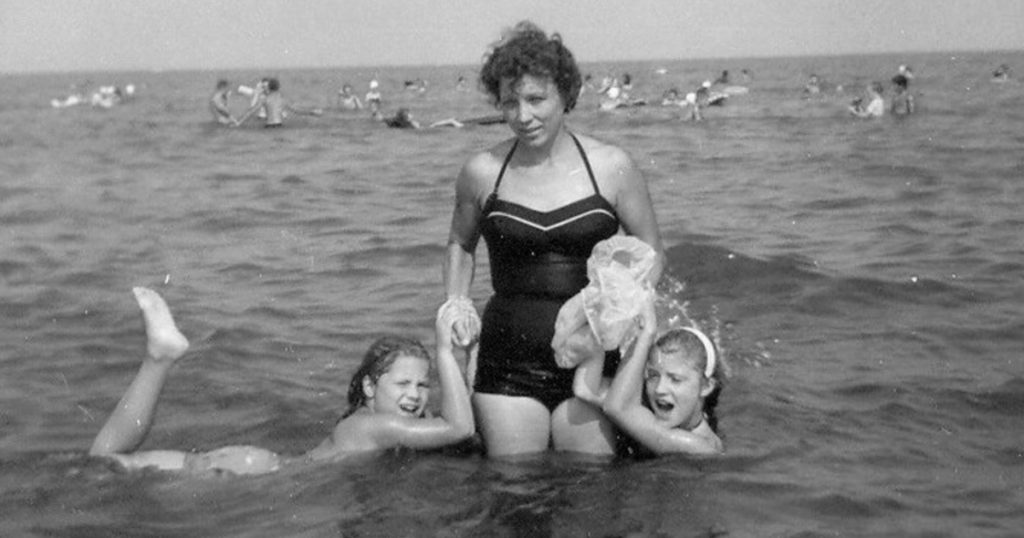 A vintage photo of lady with two girls at the beach
