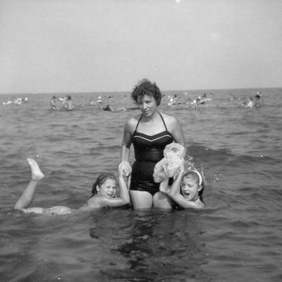 A vintage photo of lady with two girls at the beach