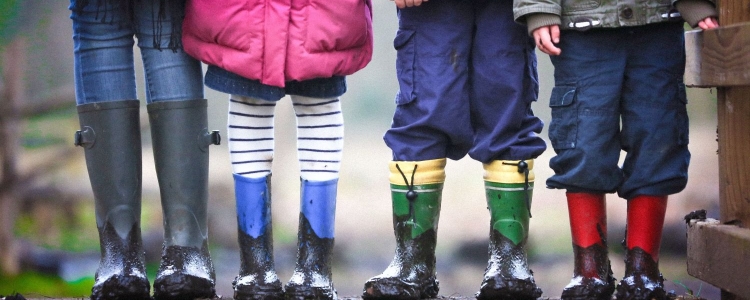 kids wearing rainboots and cold weather gear