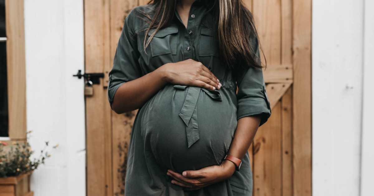 A woman wearing a maternity suit