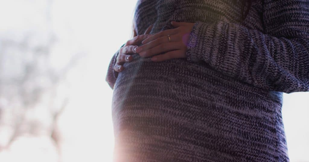 A close up of a woman\'s pregnant belly