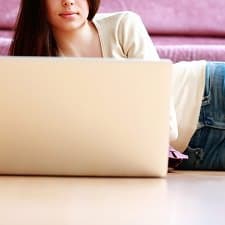 A woman sitting next to a laptop