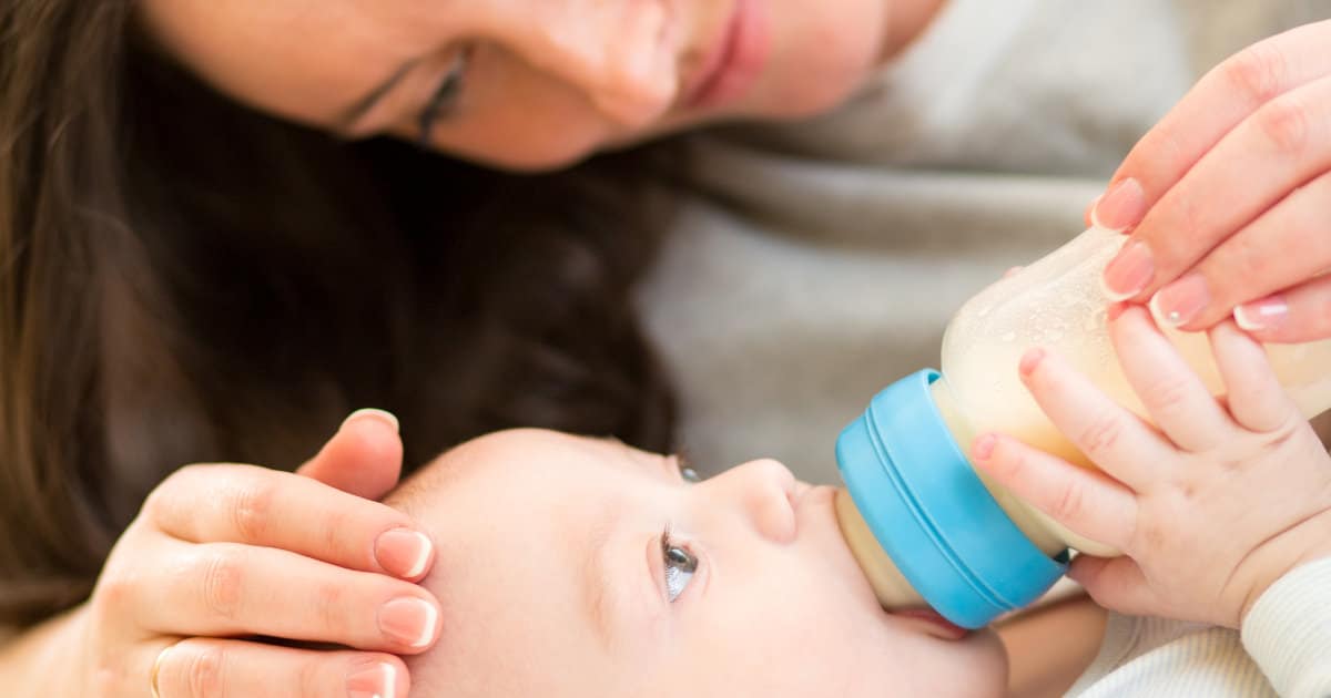 A woman bottle-feeding a baby